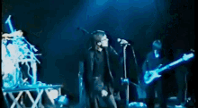 a man singing into a microphone while a man plays a guitar