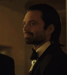 a man in a tuxedo is smiling with his eyes closed .