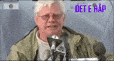 a man is speaking into a microphone with the word det e hap written above him