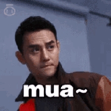 a man in a brown jacket is sitting in a chair with the word mua written on his face .