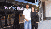 two people standing in front of a sign that says we 're making moves