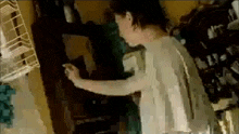 a woman without a shirt is standing in a room with a bunch of clothes on the floor .