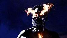 a man with flames coming out of his eyes in the dark