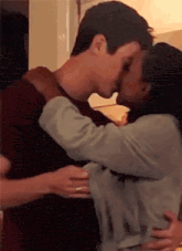 a man and a woman are kissing and hugging each other .