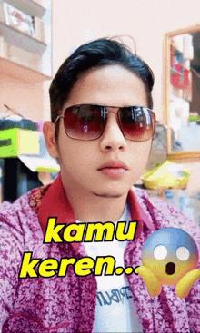a man wearing sunglasses and a purple shirt with the words kamu keren