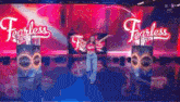 a woman is standing in front of a sign that says fearless on it