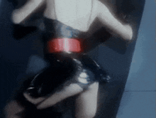 a woman in a black dress with a red belt is dancing .