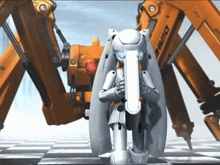 a white robot stands in front of a large orange machine that says ehrm on it