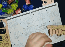 a person is holding a piece of paper with instructions on how to build a model