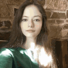 a woman is taking a selfie in front of a brick wall .