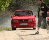 a red car with a license plate that says am068jh