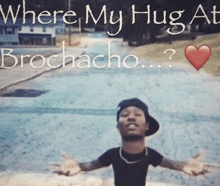 a man with his arms outstretched in front of a sign that says where my hug at brochacho ?