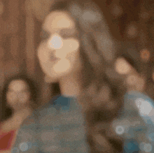 a blurry picture of a woman with long hair standing in front of two other women .