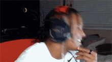 a man wearing headphones is sitting on a bed in a room .