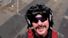 a man with a mustache wearing sunglasses and headphones is smiling