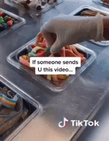 a person is putting gummy bears in a plastic container with a tiktok watermark