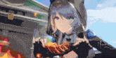a girl with a hood on is holding a piece of food in her hands
