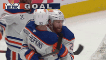 a hockey player named hopkins is hugging another player on the ice