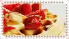 a close up of a waffle topped with strawberries and bananas .