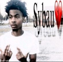 a man in a white shirt is giving the middle finger in front of a red heart .