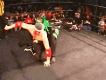 a wrestler with green hair is wrestling another wrestler
