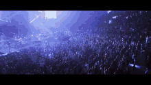 a large crowd of people watching a concert with a blue background