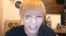 a young man with a tattoo on his face is smiling