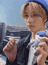 a man in a blue hat is holding a stuffed animal in his hands .