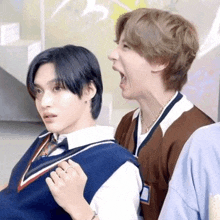a group of young men are standing next to each other and one of them is making a funny face .