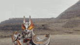 a statue of a fox with a blue eye is standing in the desert