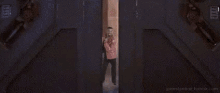 a man in a pink jacket is holding a light saber in his hand .