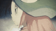 a close up of a person 's face with a green hat on