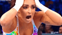 a woman is holding her head in her hands while wearing a rainbow tank top and white gloves .
