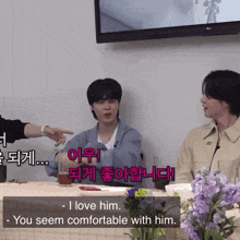 a man sits at a table with flowers and says " i love him you seem comfortable with him "