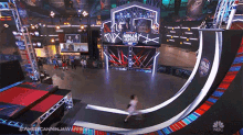 a nbc advertisement for american ninja warrior shows a person jumping over a ramp