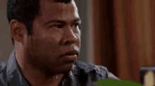 a man with sweat coming out of his face is looking at something .
