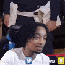 a man in a white shirt is sitting in a chair with a snapchat icon next to him