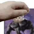 a close up of a person 's hand holding a purple object in front of a purple background .
