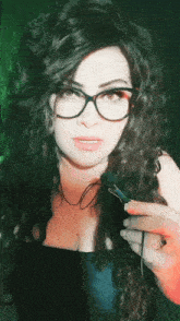 a woman wearing glasses is holding a microphone in her hand