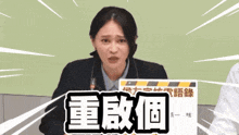 a woman is holding a sign with chinese writing