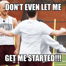 a man wearing a tank top that says ' antony ' on it is hugging another man