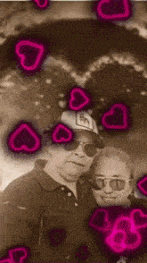 a man and a woman are posing for a photo with pink hearts surrounding them