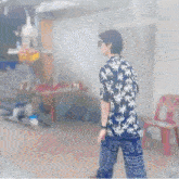 a man wearing a shirt with palm trees and elephants on the pants