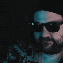 a man with a beard is wearing sunglasses and making a funny face