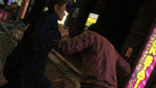 a man in a suit is talking to another man in front of a sign that says ' a '