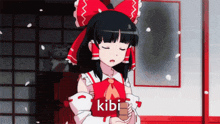 a girl with a red bow on her head is holding a book with the word kibi written on it