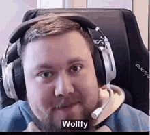 a man with a beard wearing headphones and a microphone is sitting in a chair .