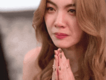 a woman is praying with her hands folded