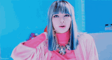 a girl with blue hair is wearing a pink shirt