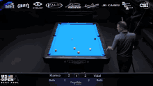 a pool table with a blue cloth and a man playing pool